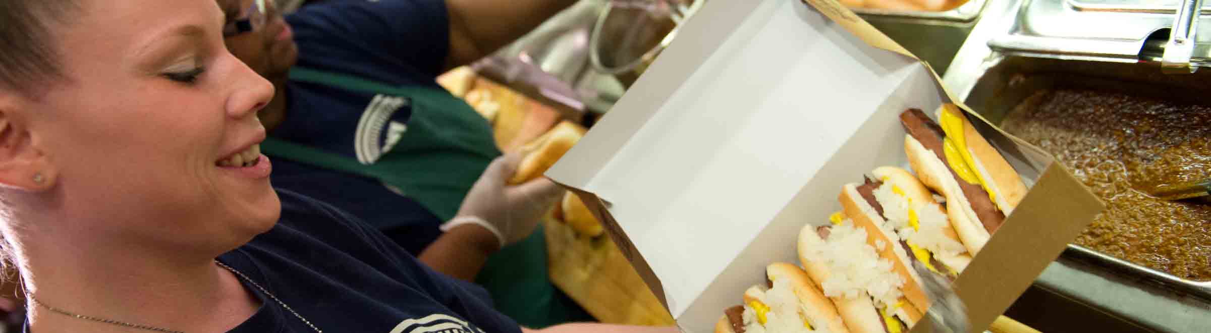 Employee preparing Tony Packo's Hot Dogs in a box at the Tony Packo Cafe