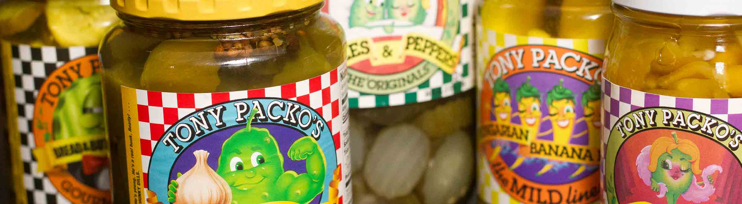 Close up of 5 jars of a variety of Tony Packos Pickles and Peppers
